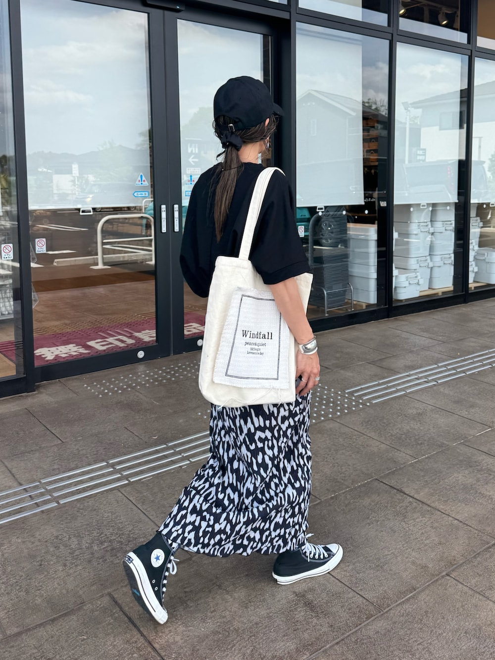 ブラック系のスニーカー、ブラック系のTシャツ/カットソー、ホワイト系のトートバッグを着用したレディースの夏コーディネートの2枚目の写真