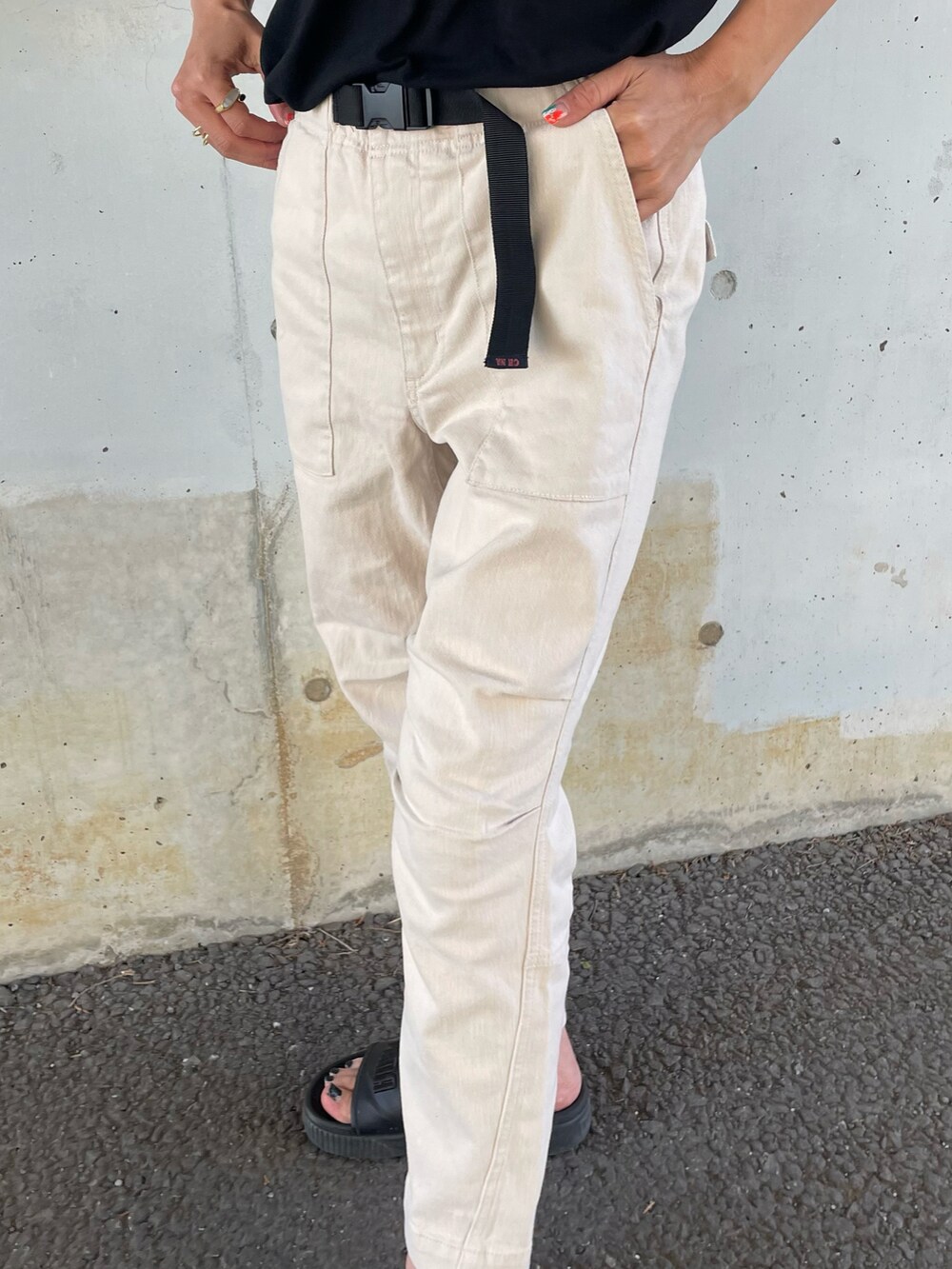 ブラック系のTシャツ/カットソー、ホワイト系のその他パンツ、ブラック系のサンダルを着用したレディースの春コーディネートの5枚目の写真