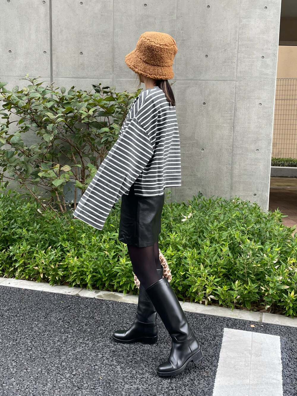 ブラック系のマウンテンパーカー、グレー系のTシャツ/カットソー、ブラック系のスカートを着用したレディースの秋コーディネートの5枚目の写真