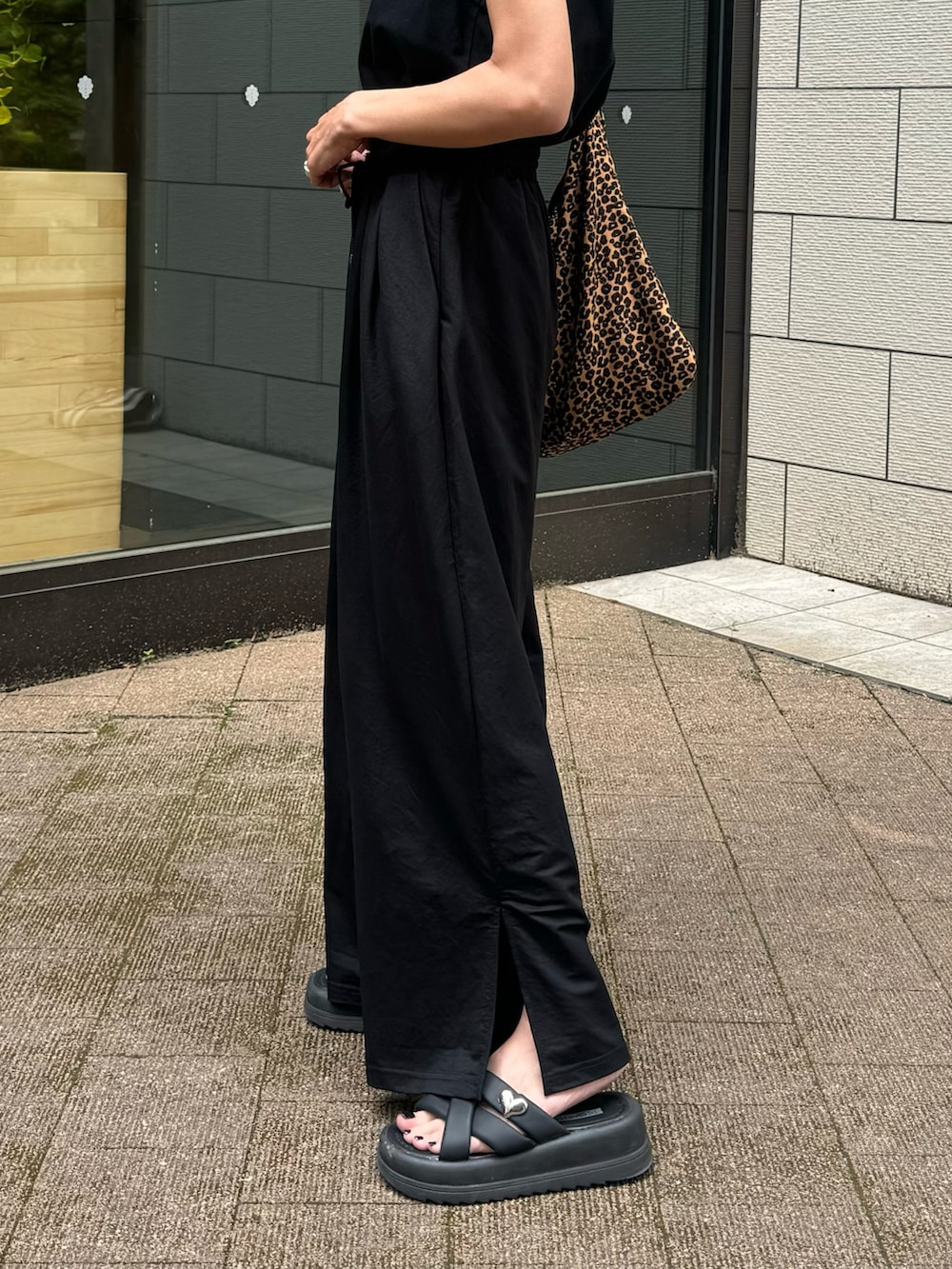ブラック系のタンクトップ、ブラック系のその他パンツ、ブラウン系のショルダーバッグを着用したレディースの夏コーディネートの5枚目の写真