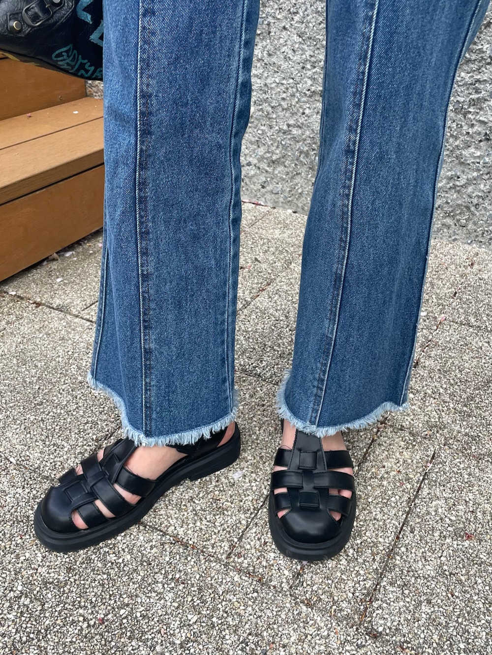 ホワイト系のTシャツ/カットソー、ブルー系のデニムパンツ、ブラック系のサンダルを着用したレディースの春コーディネートの5枚目の写真
