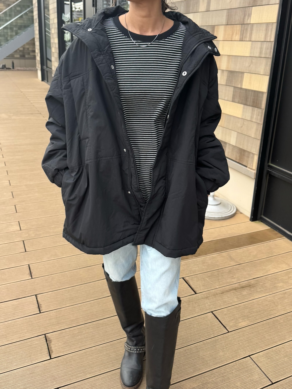 ブラック系のTシャツ/カットソー、ブルー系のデニムパンツ、ブラック系のジャケット/アウターを着用したレディースの秋コーディネートの4枚目の写真