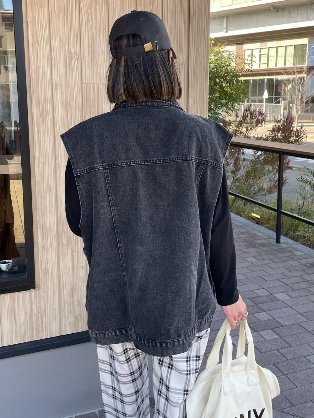 ブラック系のデニムジャケット、ブラック系のTシャツ/カットソー、ブラック系のその他パンツを着用したレディースの冬コーディネートの3枚目の写真