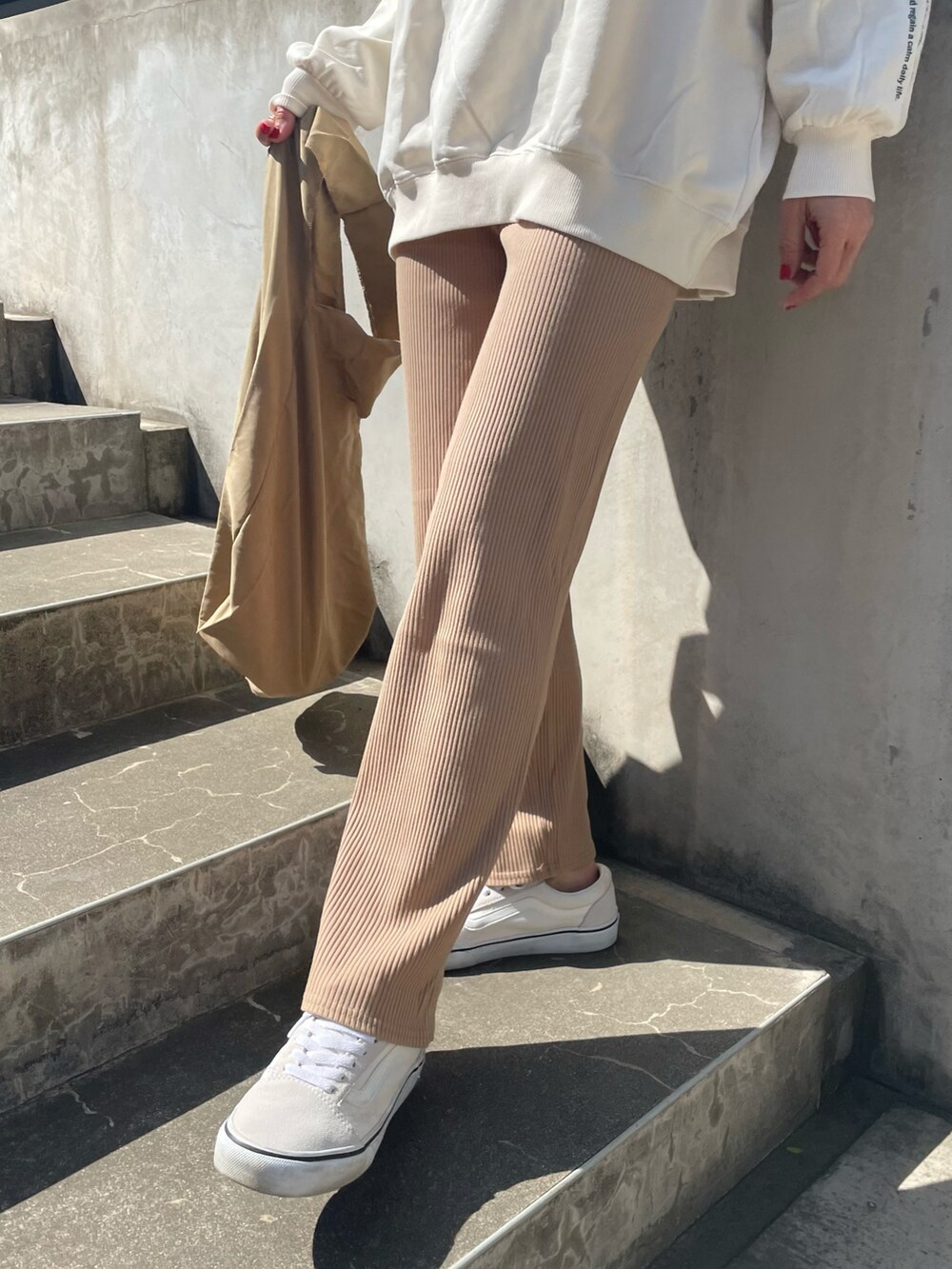 ベージュ系のその他パンツ、その他のエコバッグ/サブバッグ、ホワイト系のスニーカーを着用したレディースの春コーディネートの5枚目の写真
