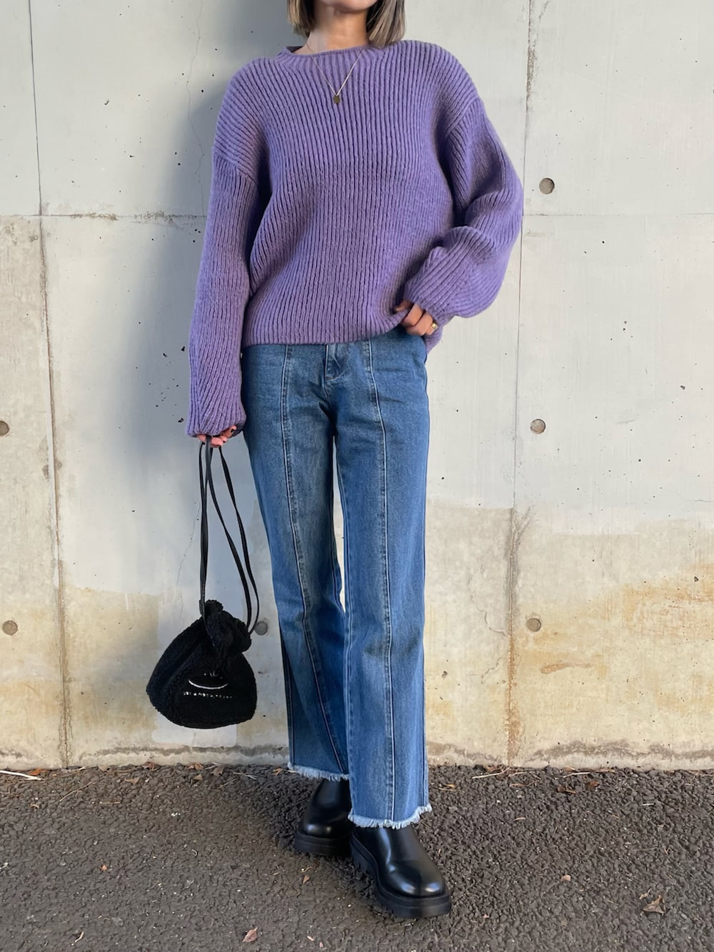 ブルー系のニット/セーター、ブラック系のダウンベスト、ブルー系のデニムパンツを着用したレディースの冬コーディネートの4枚目の写真