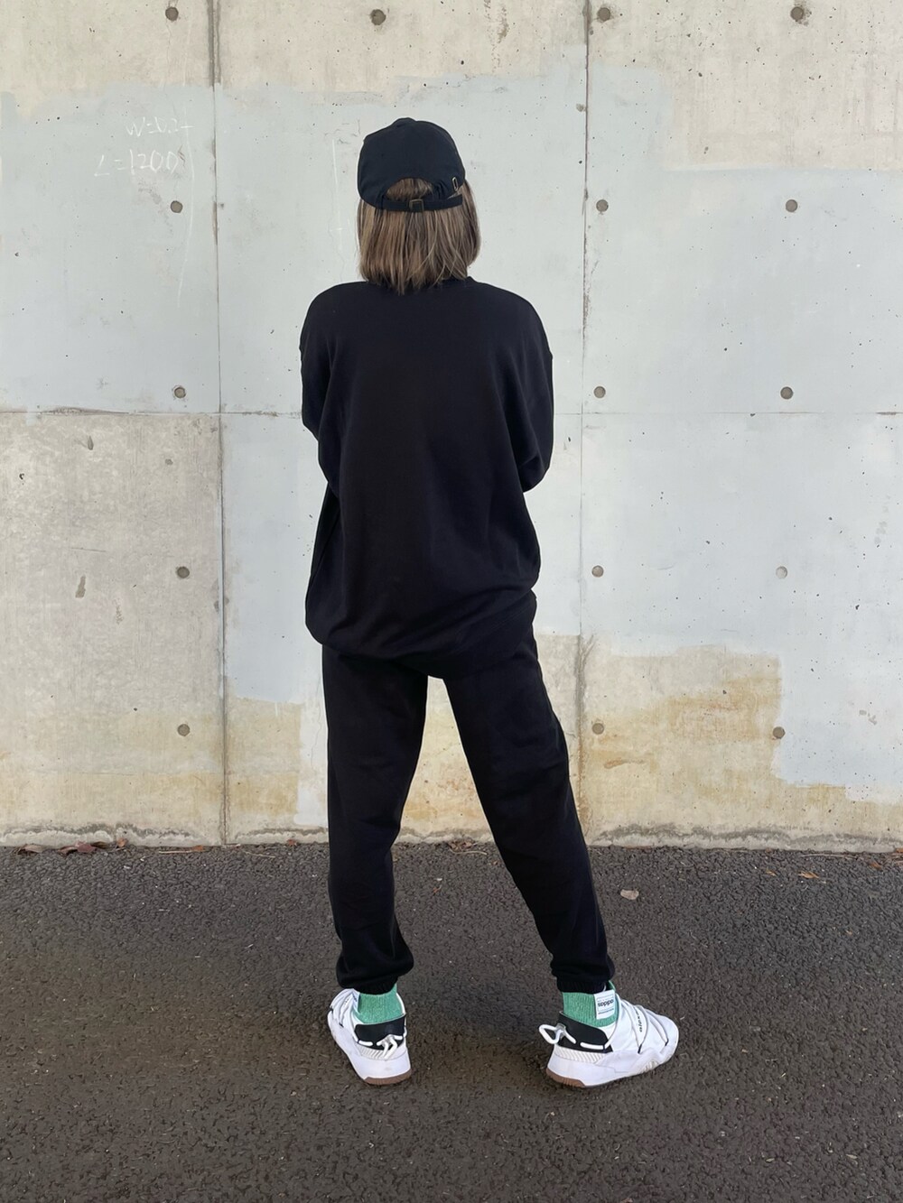 ブラック系のスウェット、ブラック系のスウェットパンツ、ホワイト系のスニーカーを着用したレディースの冬コーディネートの2枚目の写真