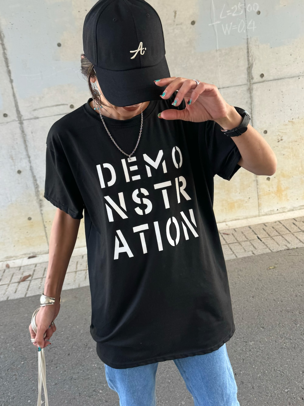 ブラック系のTシャツ/カットソー、ブルー系のデニムパンツ、ホワイト系のショルダーバッグを着用したレディースの春コーディネートの4枚目の写真