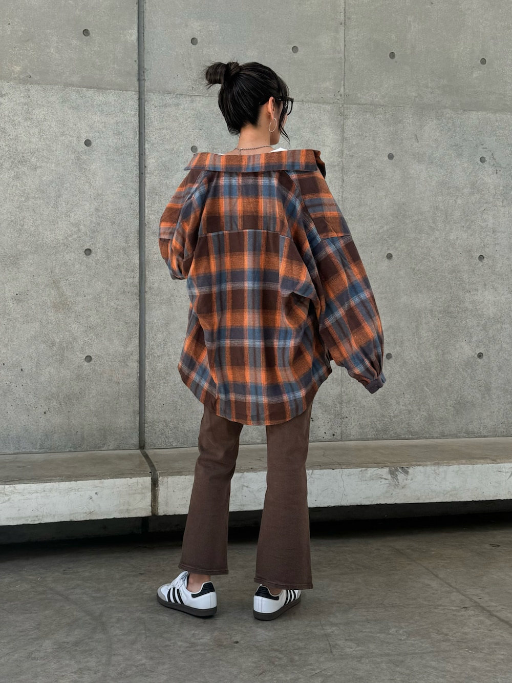ブラウン系のシャツ/ブラウス、ブラウン系のデニムパンツ、ホワイト系のスニーカーを着用したレディースの春コーディネートの2枚目の写真