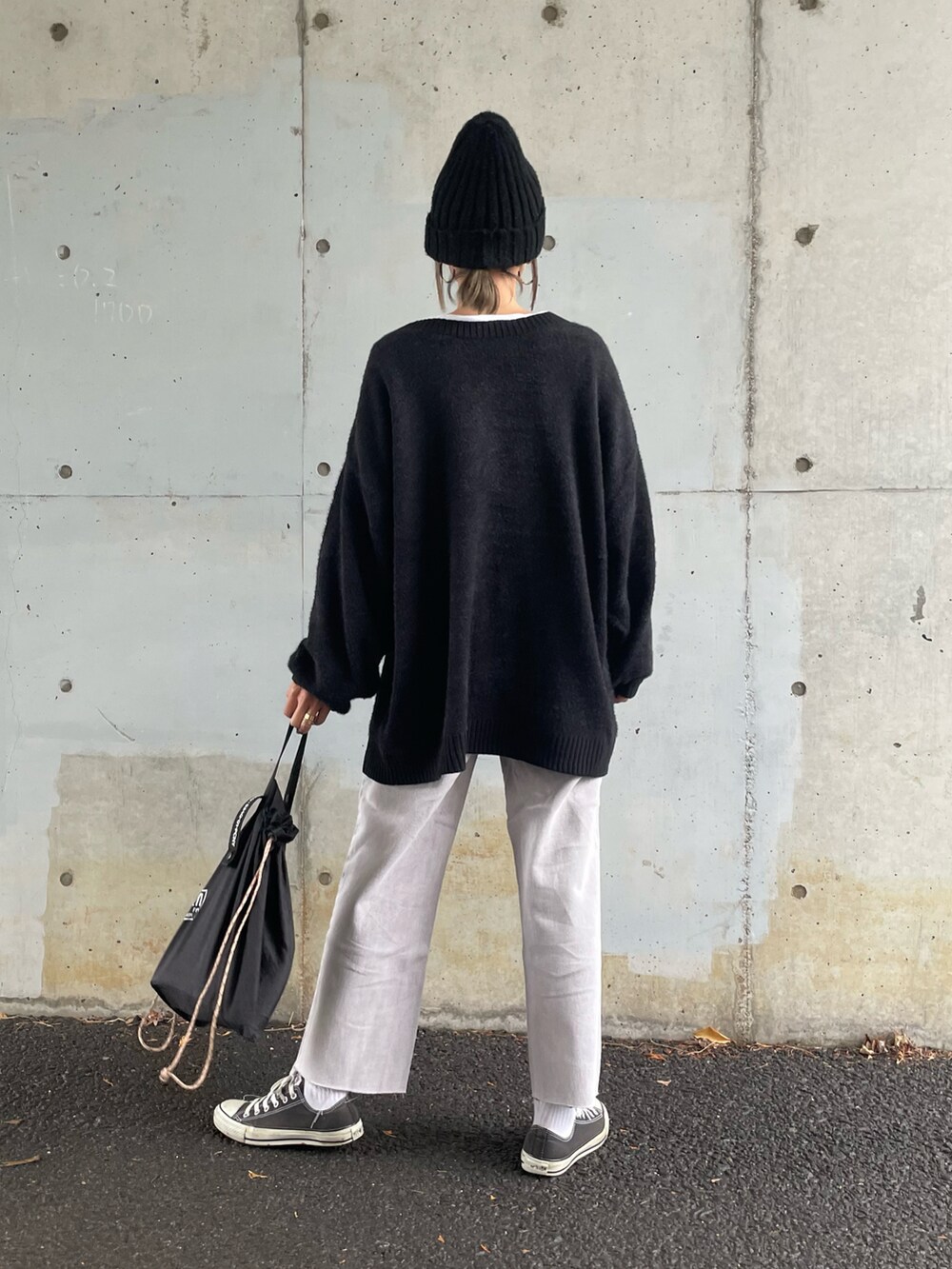 ブラック系のカーディガン/ボレロ、パープル系のデニムパンツ、ブラック系のスニーカーを着用したレディースの冬コーディネートの3枚目の写真