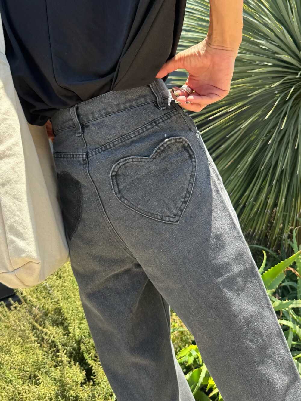 ブラック系のTシャツ/カットソー、ブラック系のデニムパンツ、ホワイト系のトートバッグを着用したレディースの夏コーディネートの5枚目の写真
