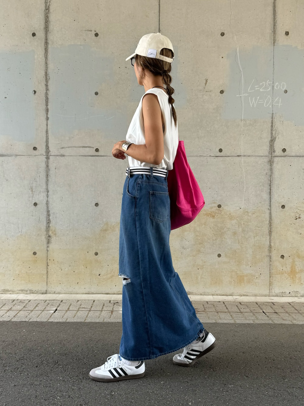 ブルー系のデニムスカート、ピンク系のトートバッグ、ホワイト系のスニーカーを着用したレディースの夏コーディネートの3枚目の写真