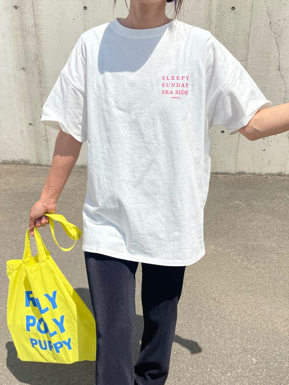 レッド系のTシャツ/カットソー、イエロー系のトートバッグ、ホワイト系のスニーカーを着用したレディースの春コーディネートの4枚目の写真