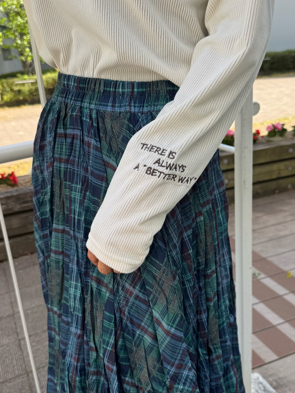 ホワイト系のTシャツ/カットソー、グリーン系のスカート、ホワイト系のスニーカーを着用したレディースの春コーディネートの5枚目の写真