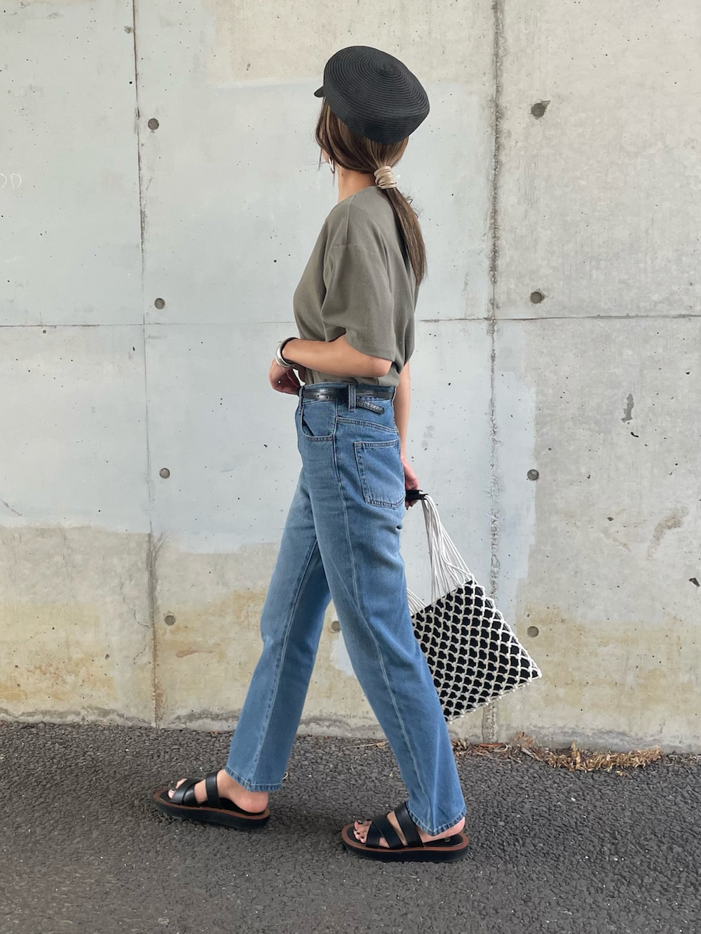 グリーン系のTシャツ/カットソー、ブルー系のデニムパンツ、その他のハンドバッグを着用したレディースの夏コーディネートの2枚目の写真