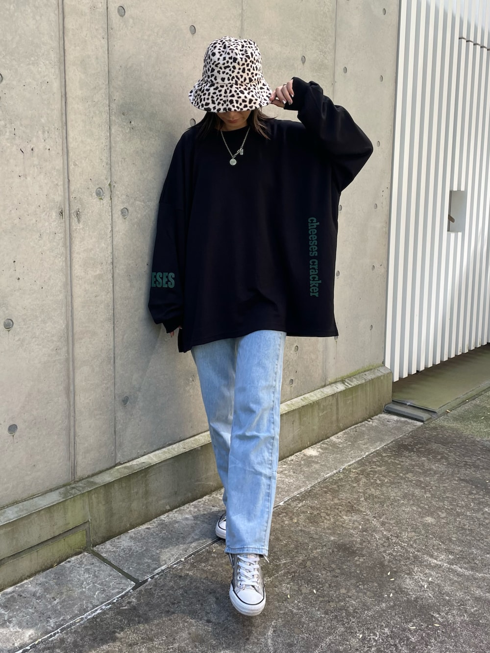 ブラック系のスウェット、ブルー系のデニムパンツ、シルバー系のスニーカーを着用したレディースの秋コーディネートの3枚目の写真