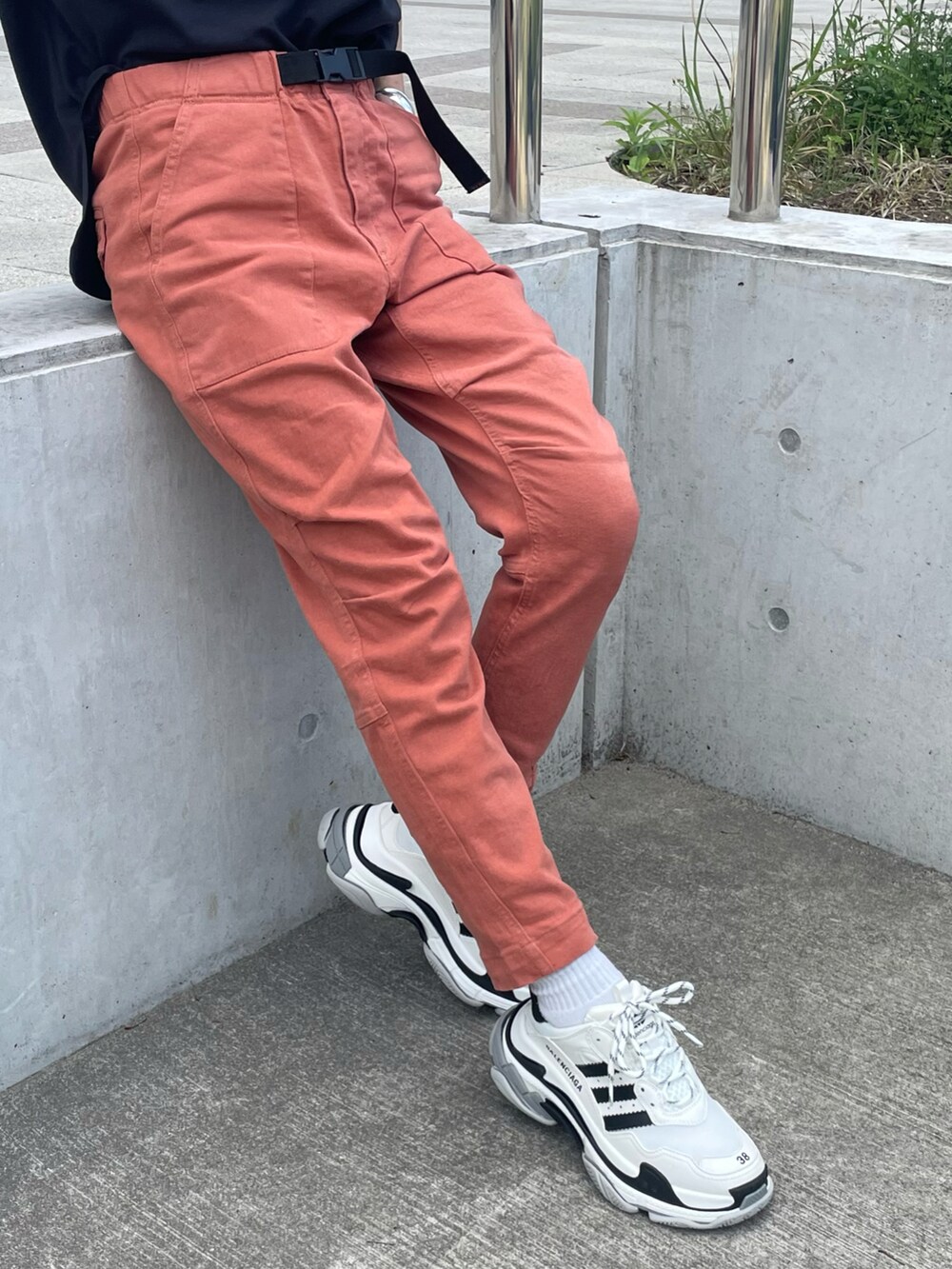 ブラック系のTシャツ/カットソー、レッド系のその他パンツ、ブラック系のバッグを着用したレディースの春コーディネートの4枚目の写真