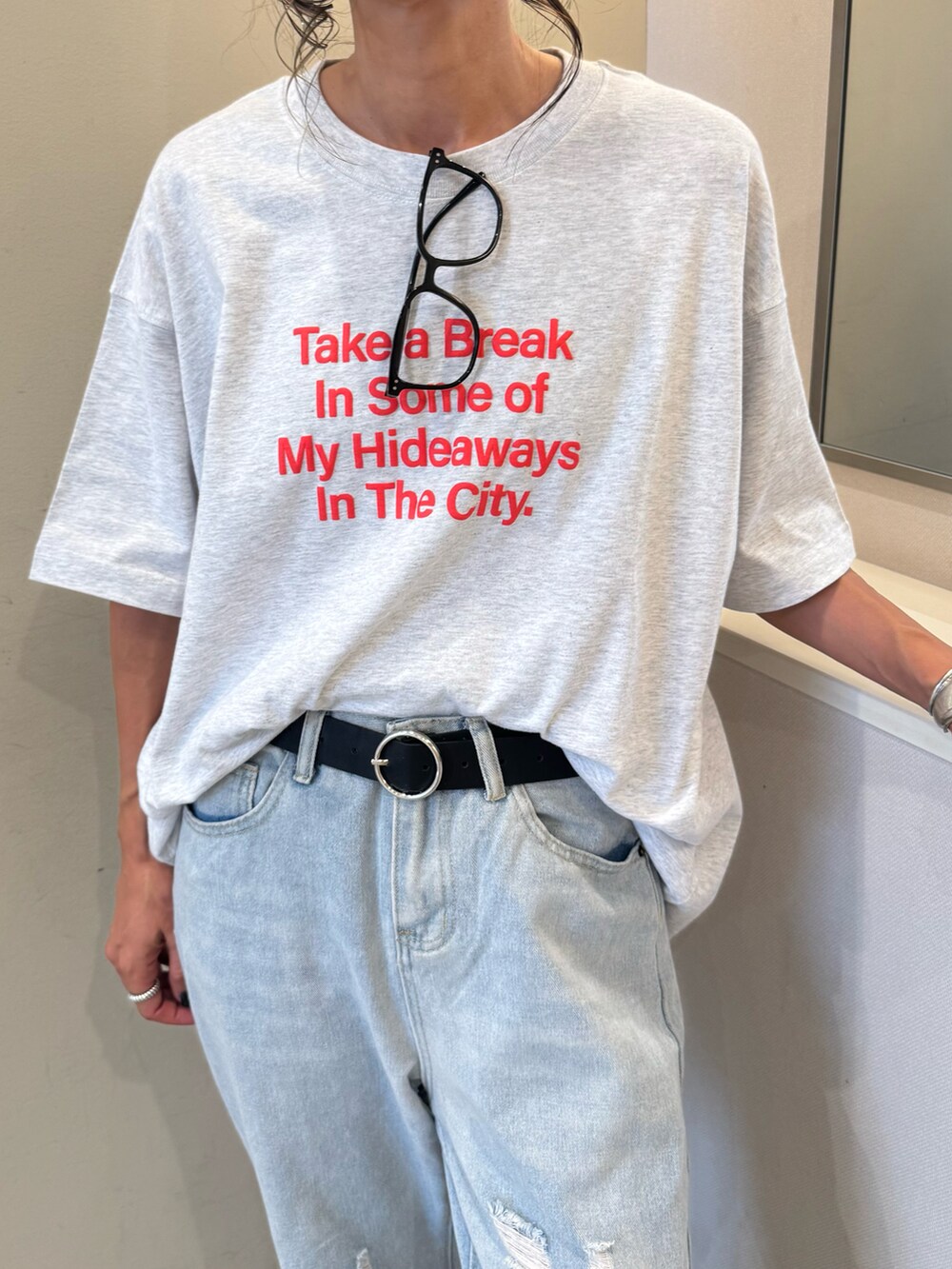 ホワイト系のスニーカー、グレー系のTシャツ/カットソー、ブルー系のデニムパンツを着用したレディースの夏コーディネートの3枚目の写真