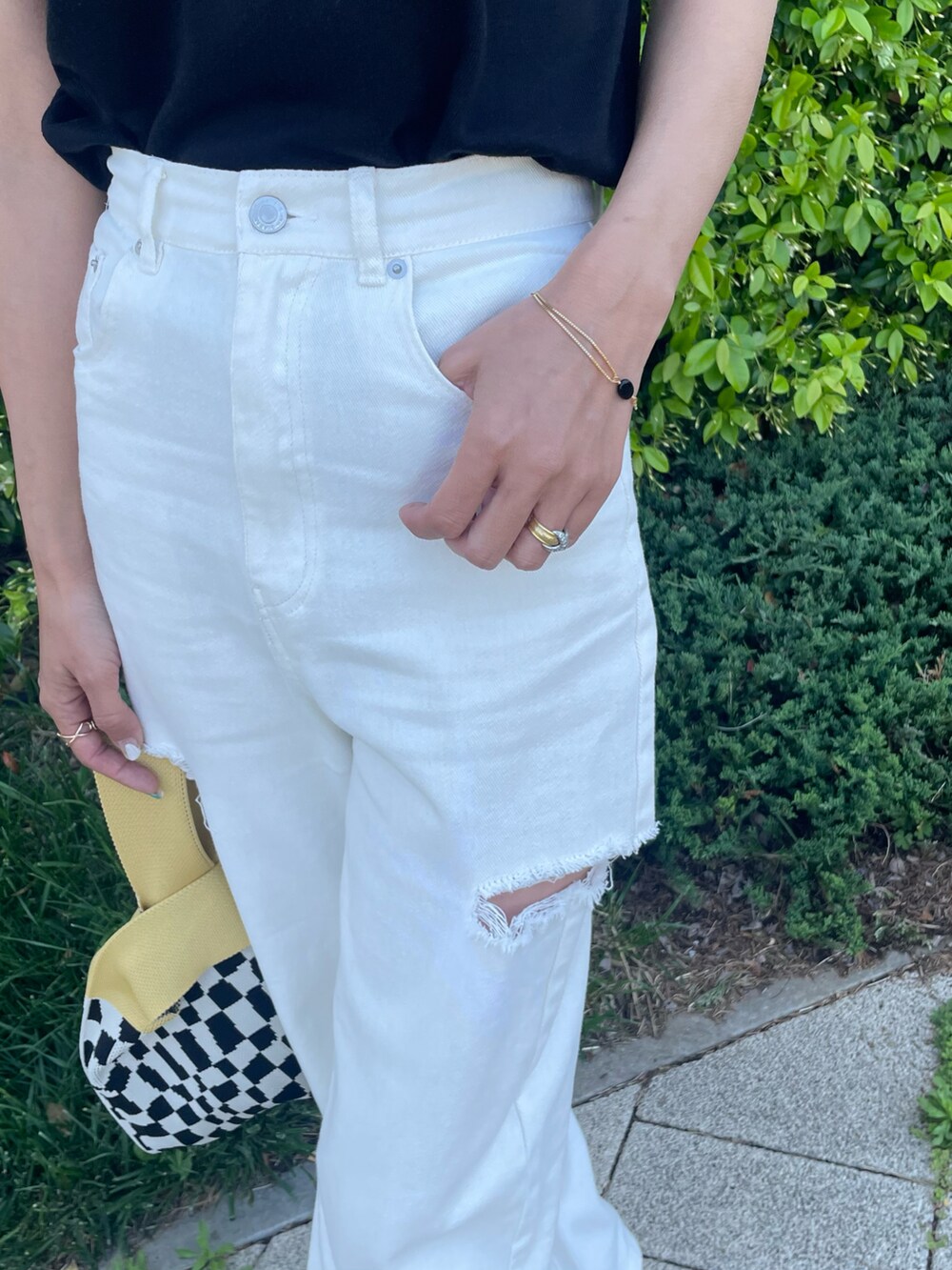 ブラック系のTシャツ/カットソー、ホワイト系のデニムパンツ、イエロー系のハンドバッグを着用したレディースの春コーディネートの5枚目の写真