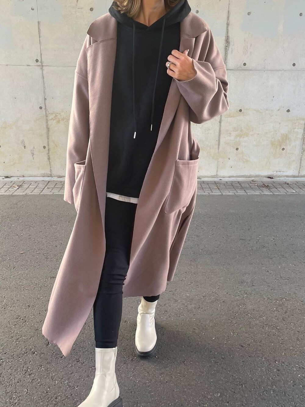 ブラウン系のチェスターコート、ブラック系のパーカー、ブラック系のその他パンツを着用したレディースの秋コーディネートの5枚目の写真