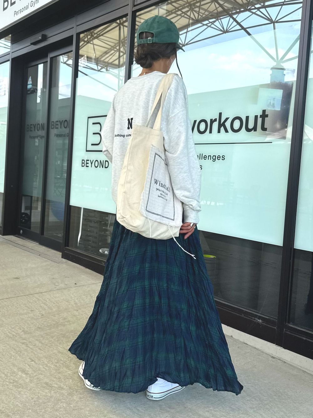 ホワイト系のスニーカー、ホワイト系のスウェット、グリーン系のスカートを着用したレディースの秋コーディネートの3枚目の写真