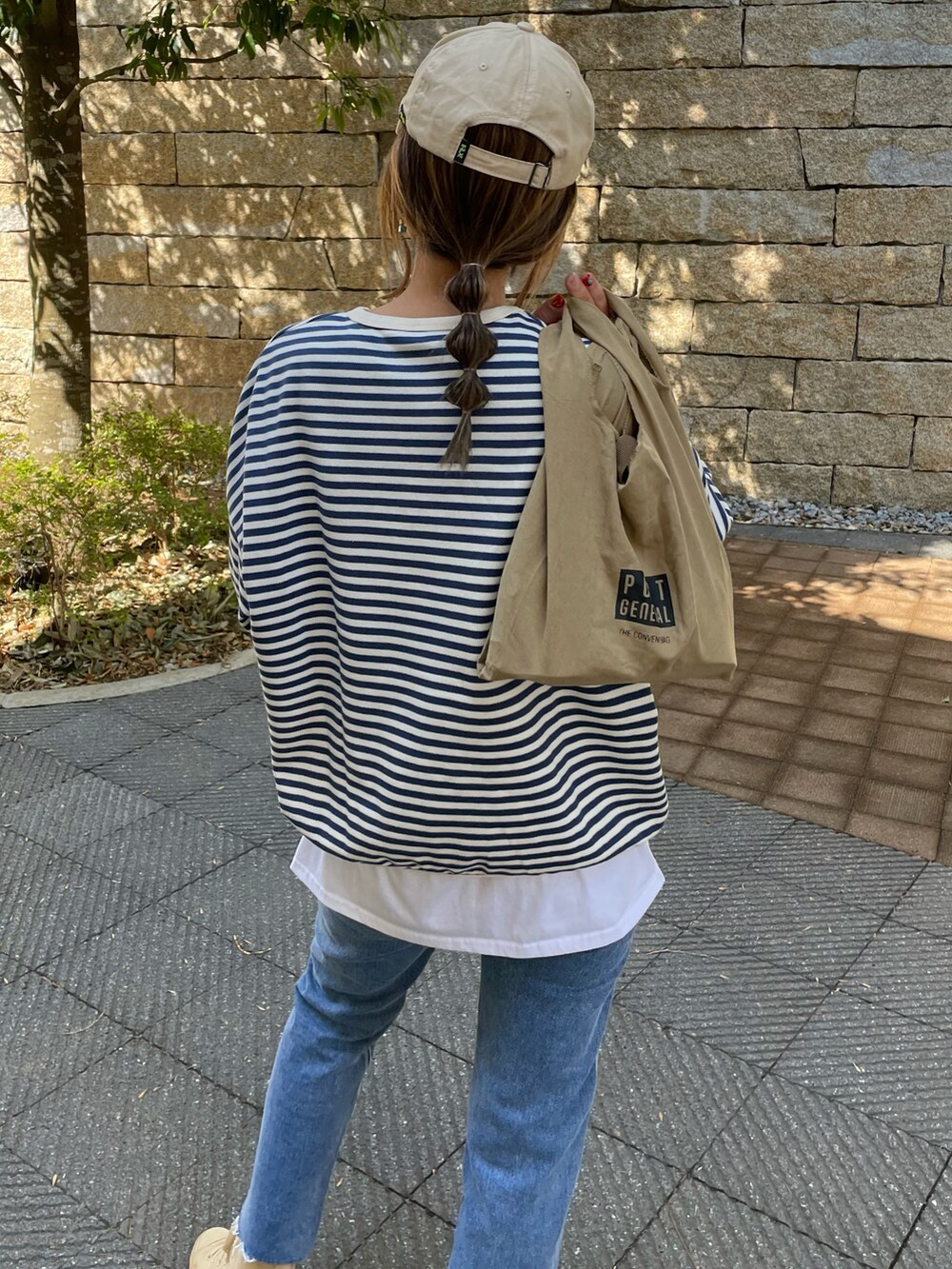 ブルー系のTシャツ/カットソー、ブルー系のデニムパンツ、その他のエコバッグ/サブバッグを着用したレディースの春コーディネートの5枚目の写真