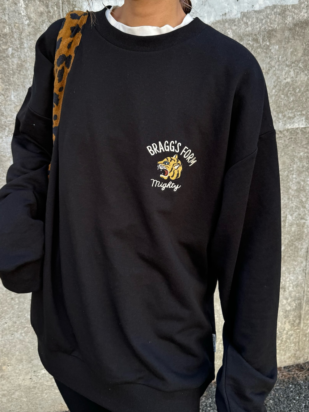 ブラック系のスウェット、ブラウン系のトートバッグ、ブラック系のその他パンツを着用したレディースの秋コーディネートの4枚目の写真