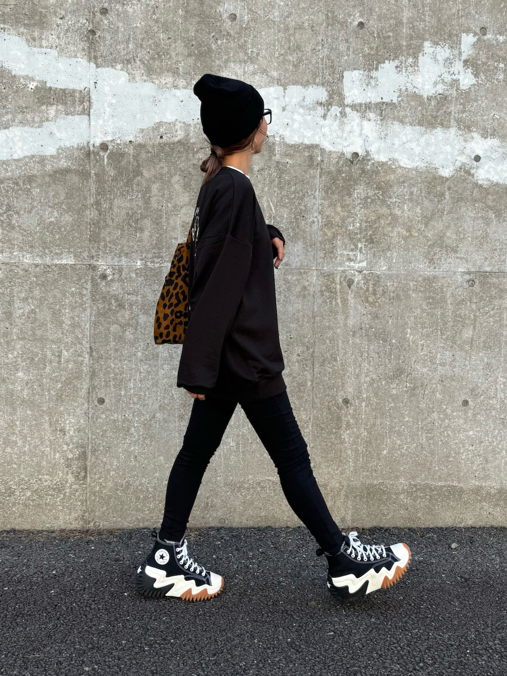 ブラック系のスウェット、ブラウン系のトートバッグ、ブラック系のその他パンツを着用したレディースの秋コーディネートの2枚目の写真