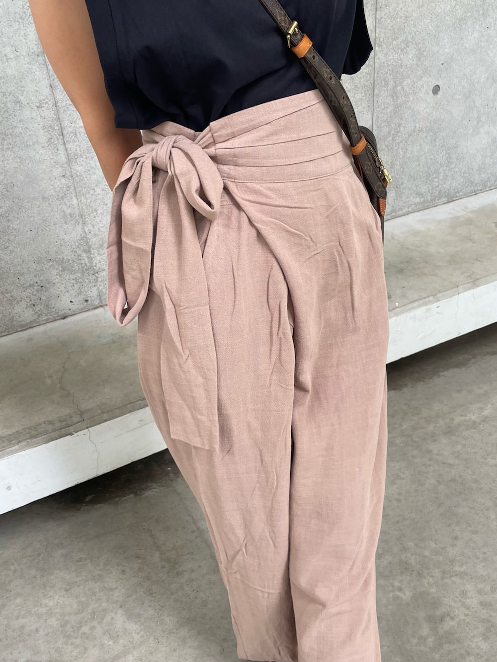 ブラック系のTシャツ/カットソー、ベージュ系のその他パンツ、ブラック系のサンダルを着用したレディースの夏コーディネートの5枚目の写真