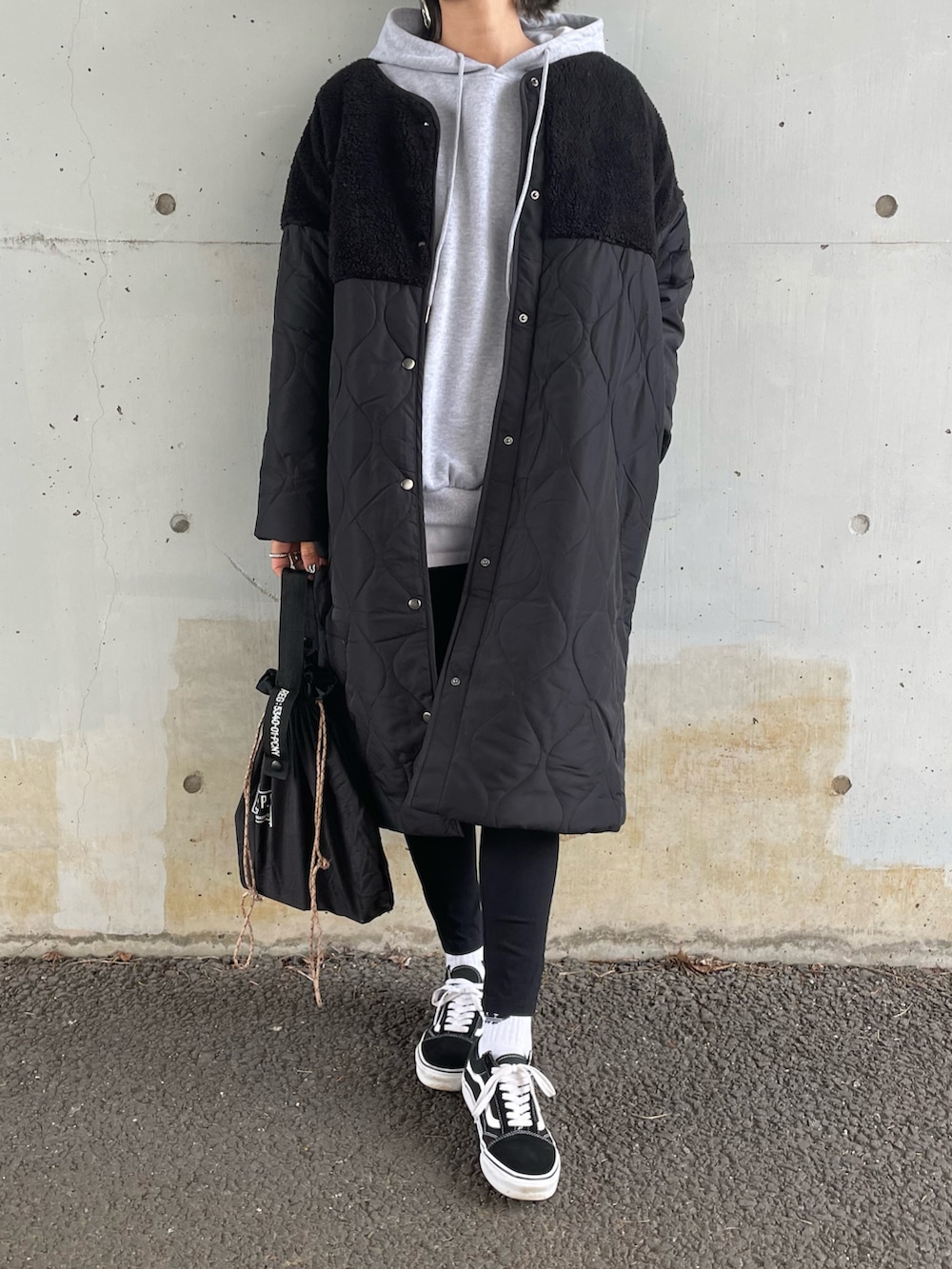 グレー系のパーカー、ブラック系のノーカラージャケット、ブラック系のその他パンツを着用したレディースの秋コーディネートの2枚目の写真