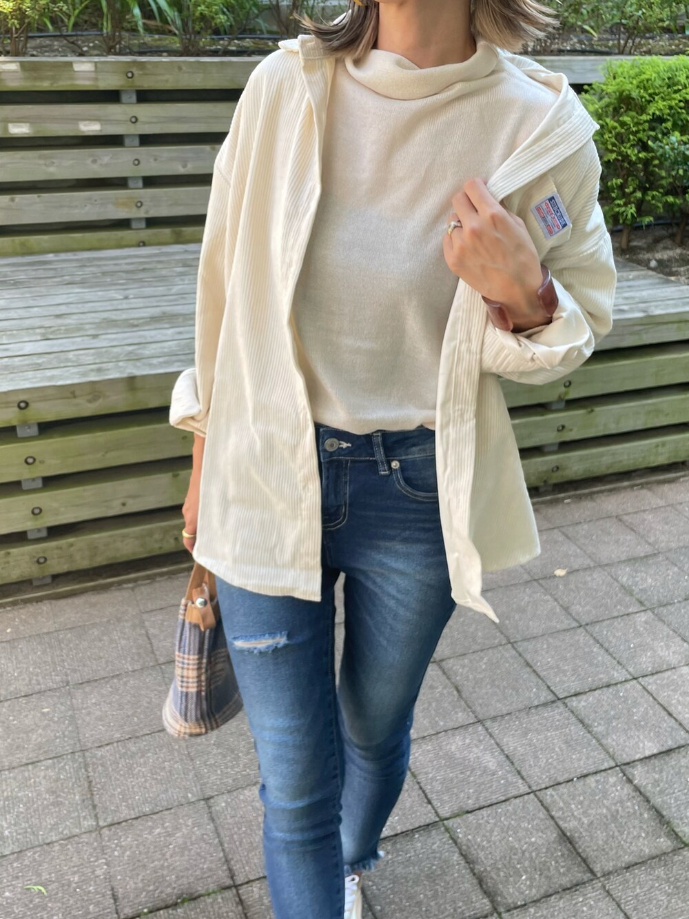 ホワイト系のシャツ/ブラウス、ホワイト系のニット/セーター、ブルー系のデニムパンツを着用したレディースの秋コーディネートの5枚目の写真