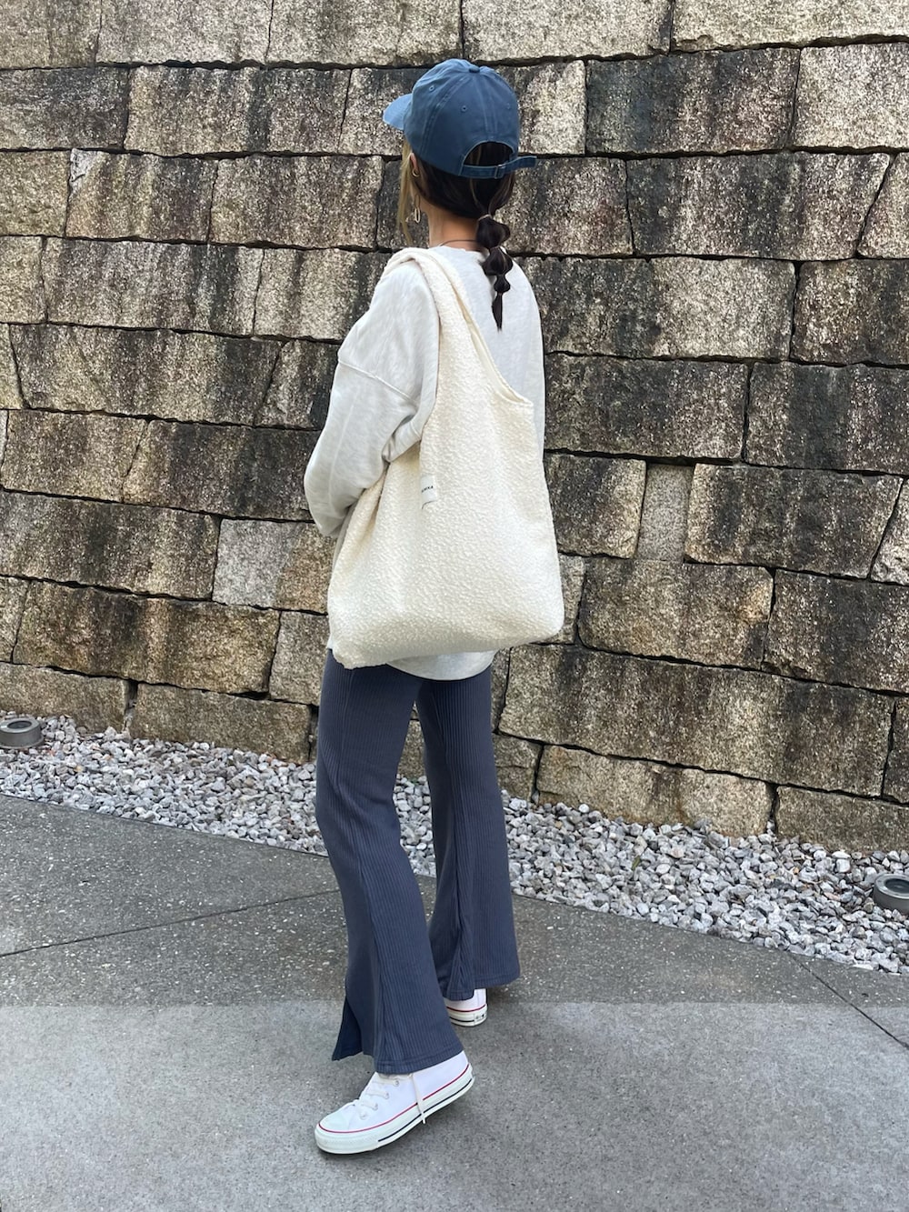 ブルー系のその他パンツ、ホワイト系のトートバッグ、ホワイト系のスニーカーを着用したレディースの秋コーディネートの2枚目の写真