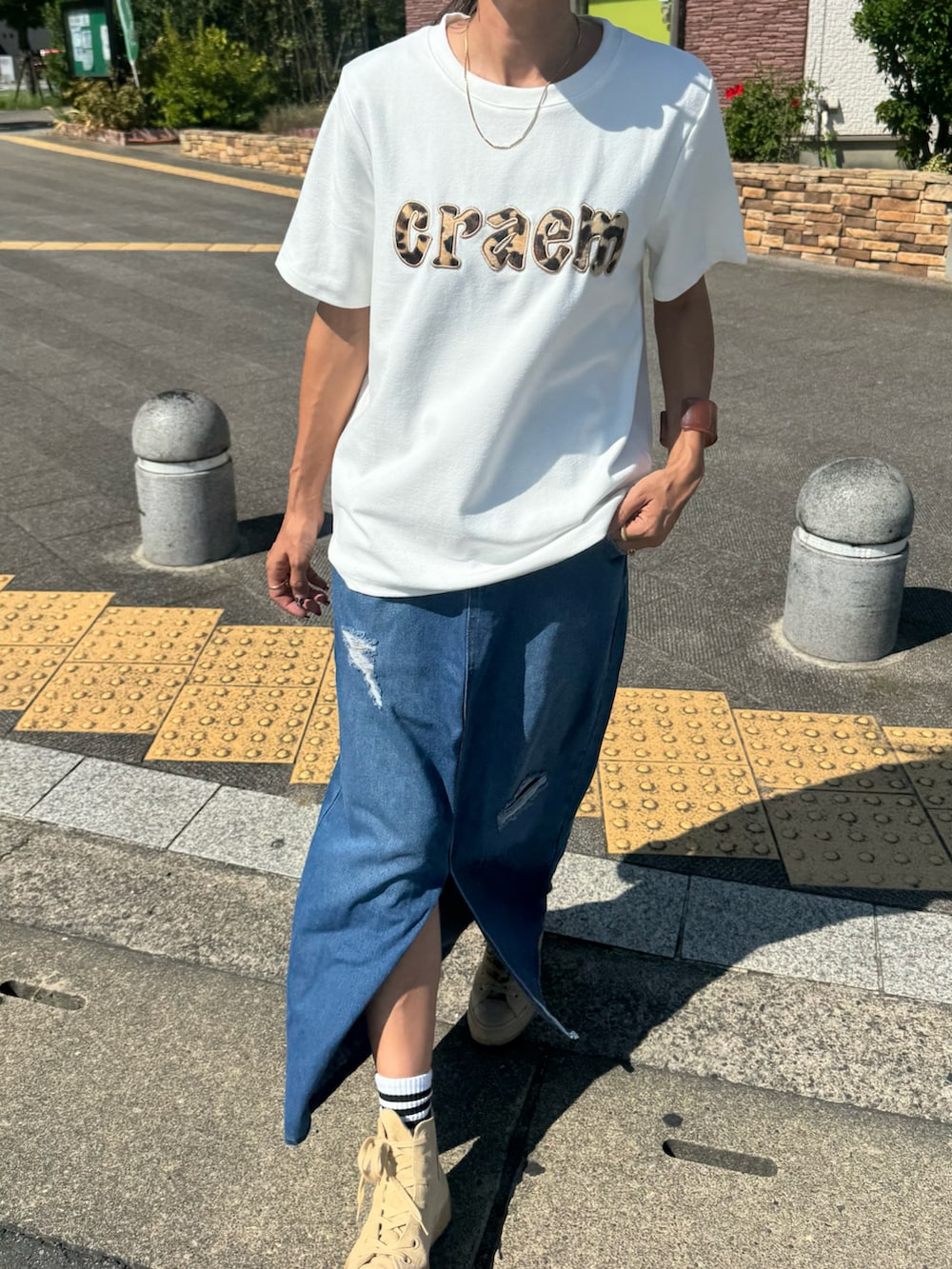 ホワイト系のTシャツ/カットソー、ブルー系のデニムスカート、ベージュ系のスニーカーを着用したレディースの秋コーディネートの2枚目の写真