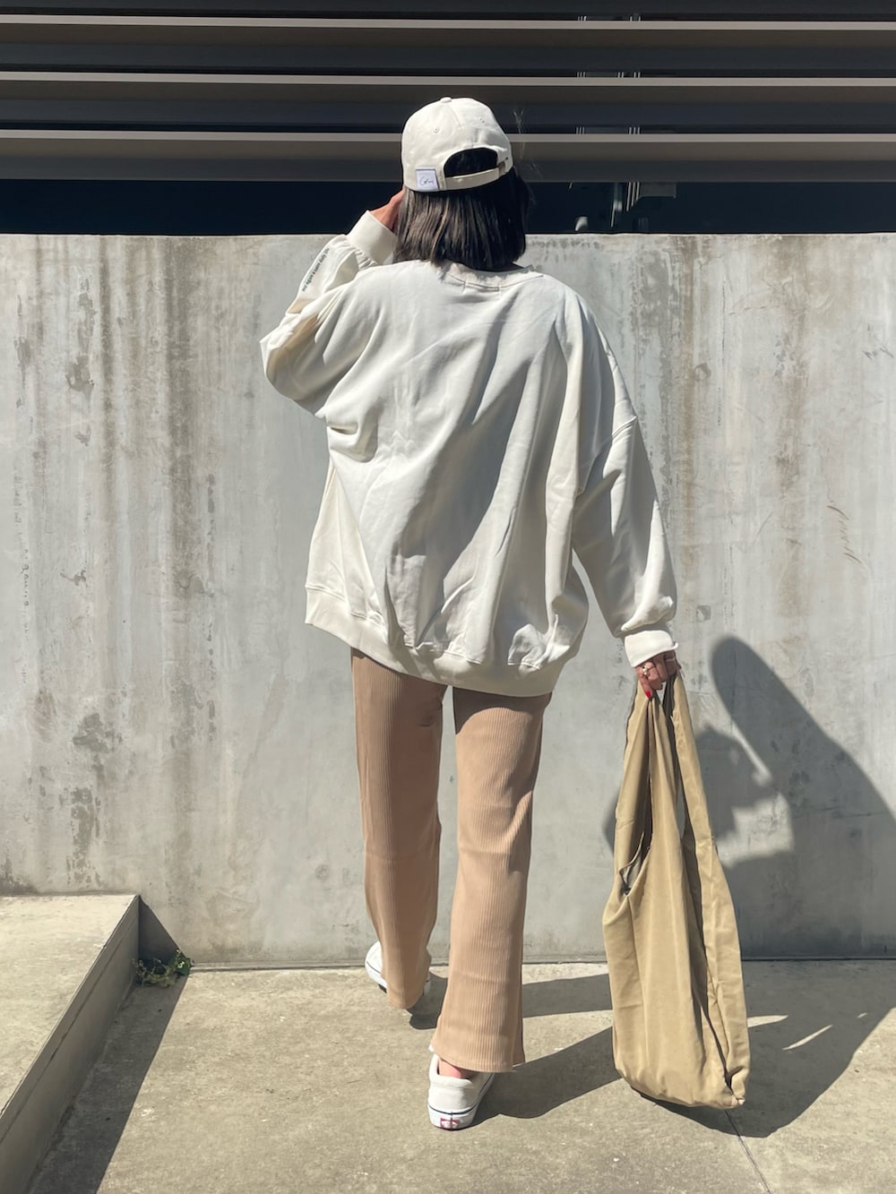 ベージュ系のその他パンツ、その他のエコバッグ/サブバッグ、ホワイト系のスニーカーを着用したレディースの春コーディネートの2枚目の写真