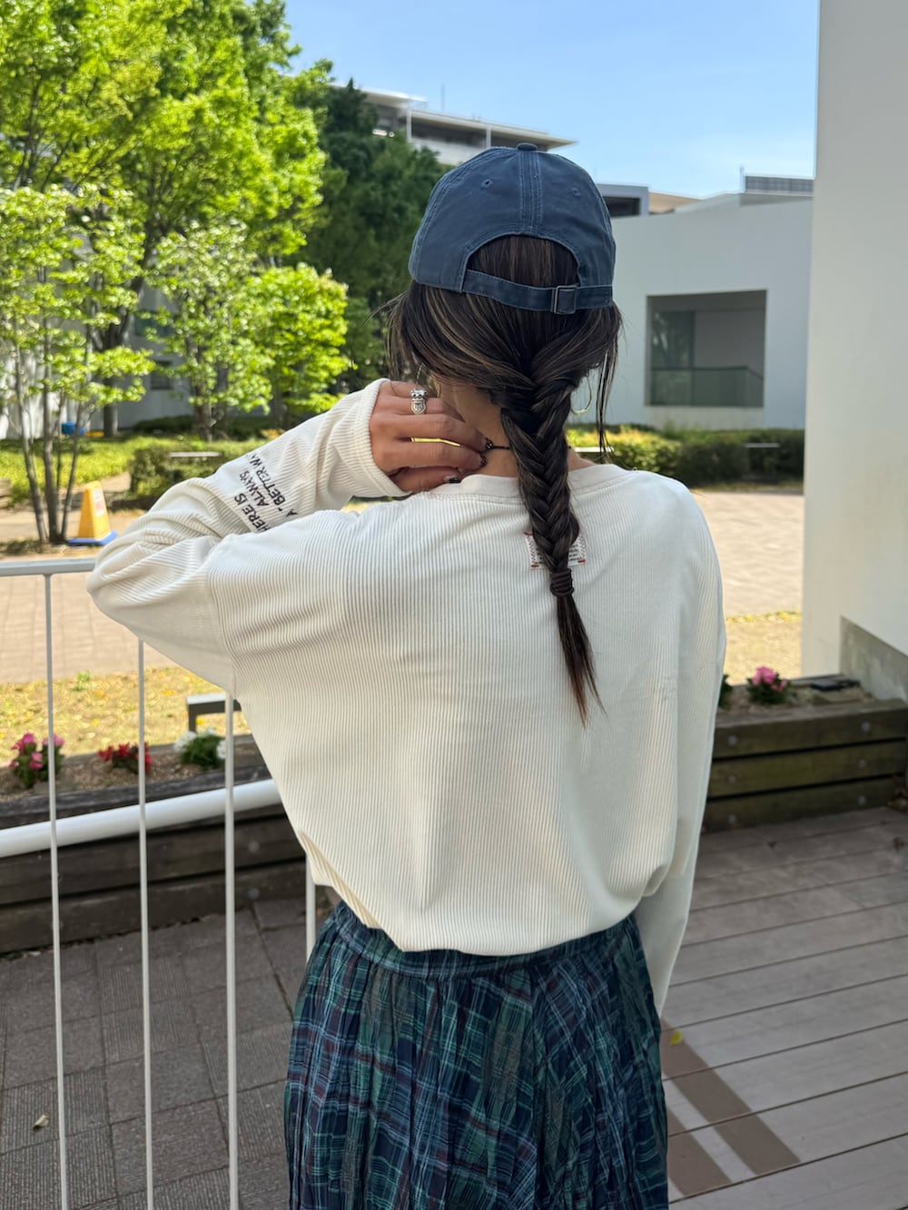 ホワイト系のTシャツ/カットソー、グリーン系のスカート、ホワイト系のスニーカーを着用したレディースの春コーディネートの4枚目の写真