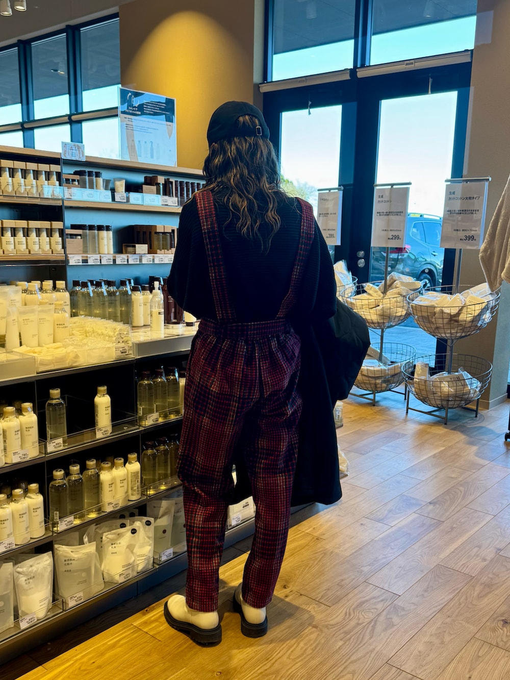 レッド系のサロペット/オーバーオール、ブラック系のジャケット/アウター、ブラック系のニット/セーターを着用したレディースの冬コーディネートの4枚目の写真