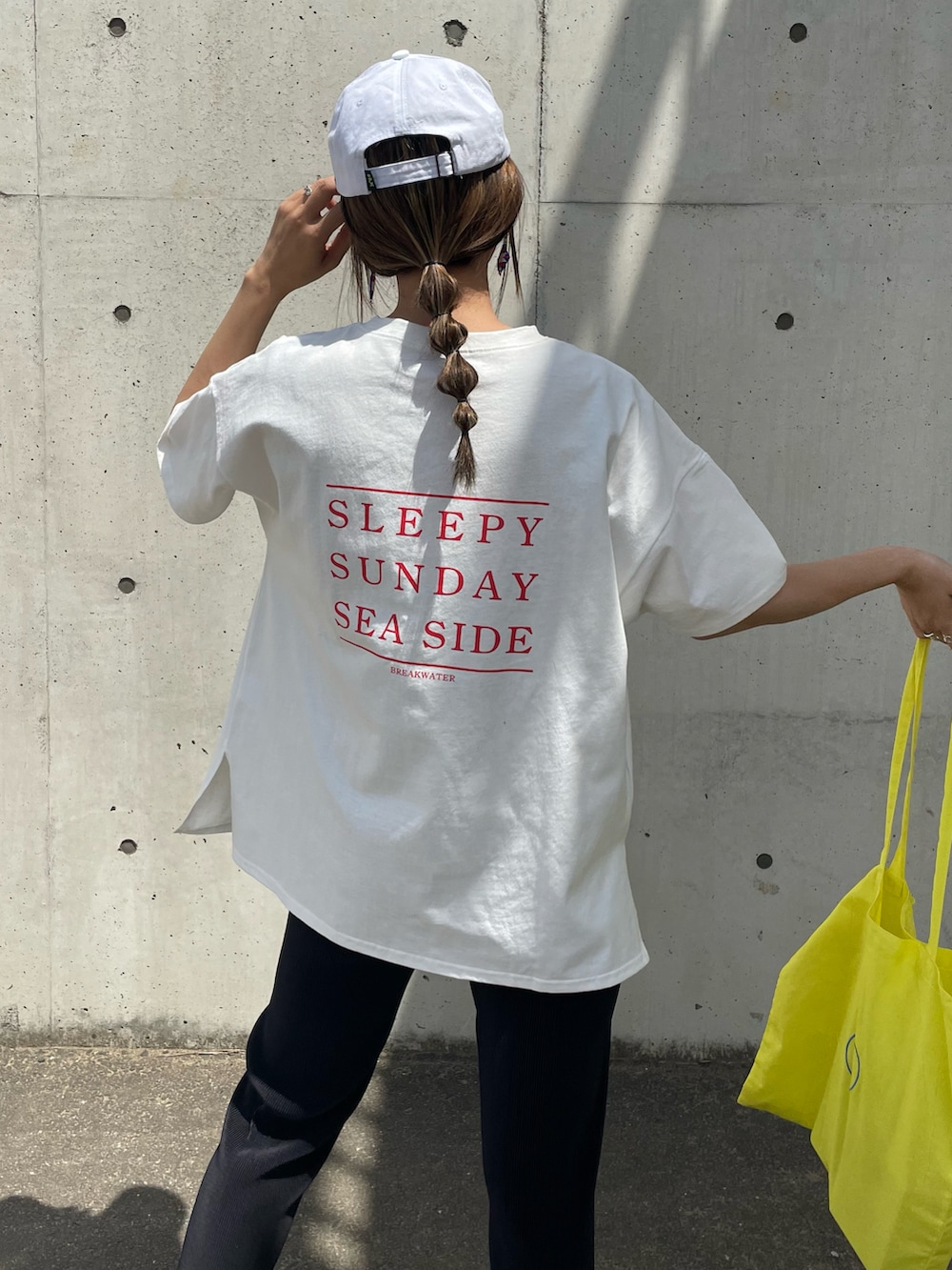 レッド系のTシャツ/カットソー、イエロー系のトートバッグ、ホワイト系のスニーカーを着用したレディースの春コーディネートの5枚目の写真