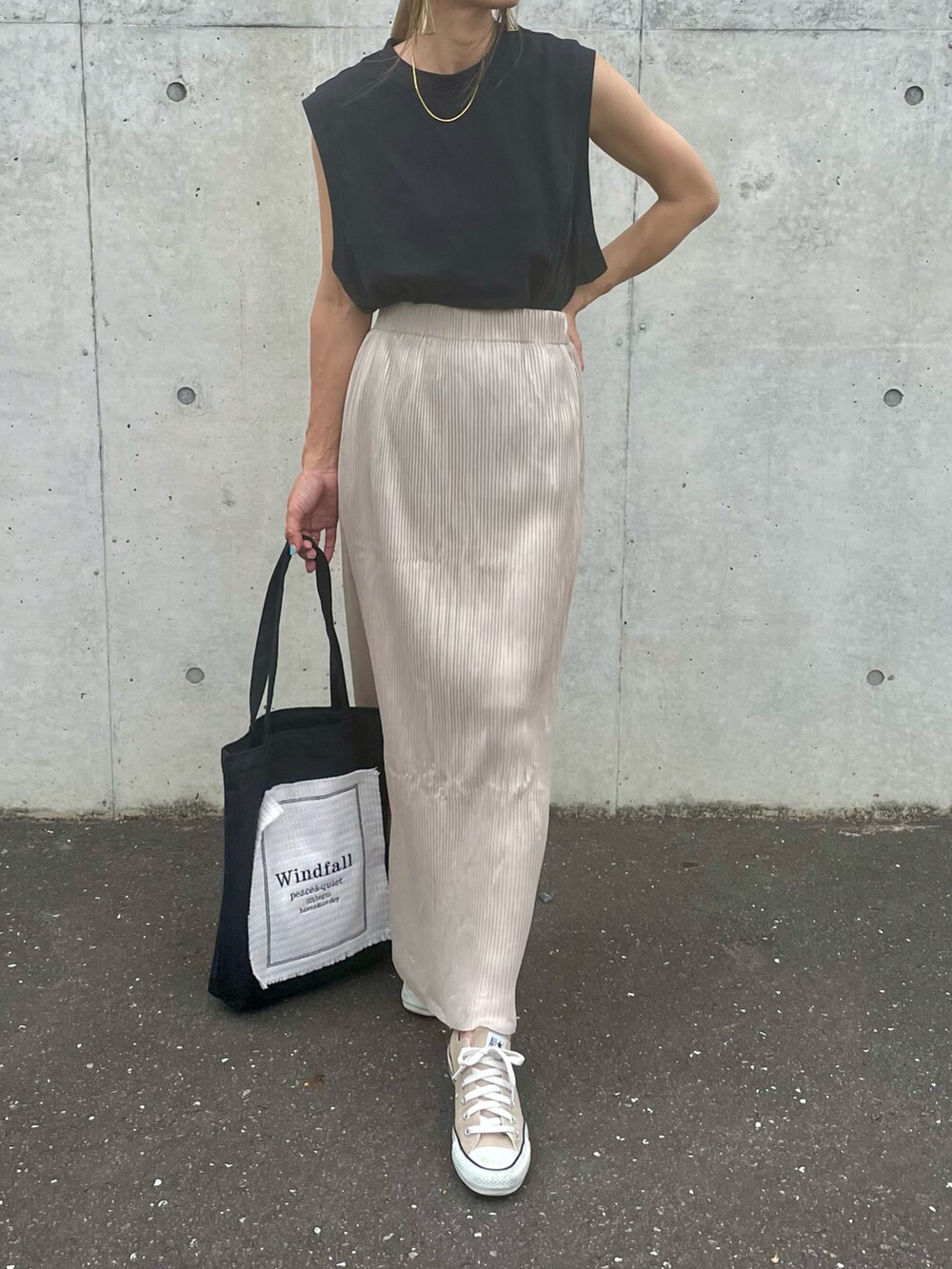ブラック系のTシャツ/カットソー、ベージュ系のスカート、ブラック系のトートバッグを着用したレディースの夏コーディネートの2枚目の写真