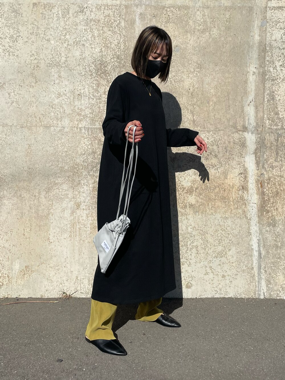ブラック系のワンピース、グレー系のショルダーバッグ、ブルー系のデニムジャケットを着用したレディースの春コーディネートの4枚目の写真