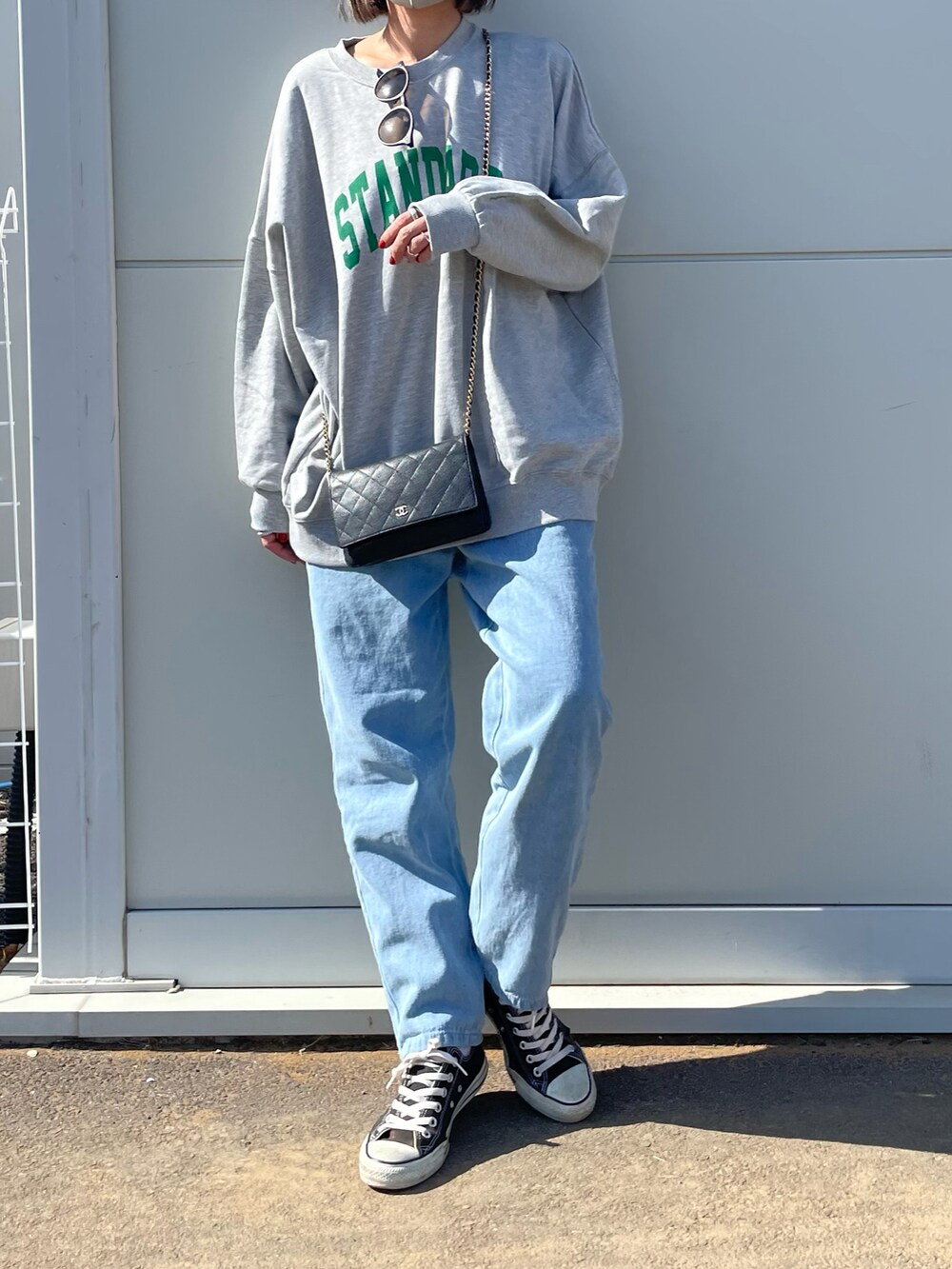 ブルー系のデニムパンツ、ブラック系のスニーカー、ブラウン系のキャップを着用したレディースの冬コーディネートの2枚目の写真
