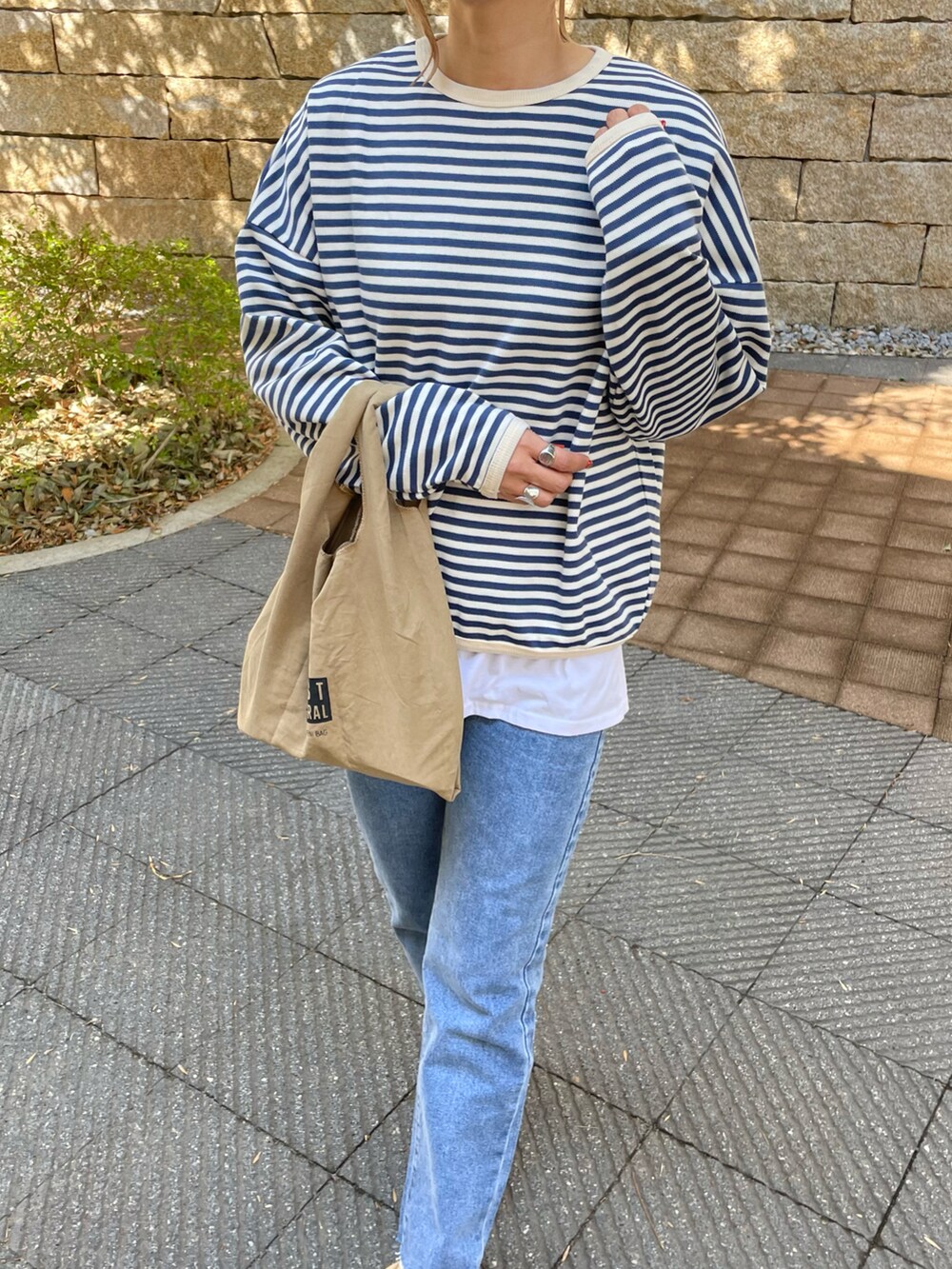 ブルー系のTシャツ/カットソー、ブルー系のデニムパンツ、その他のエコバッグ/サブバッグを着用したレディースの春コーディネートの4枚目の写真