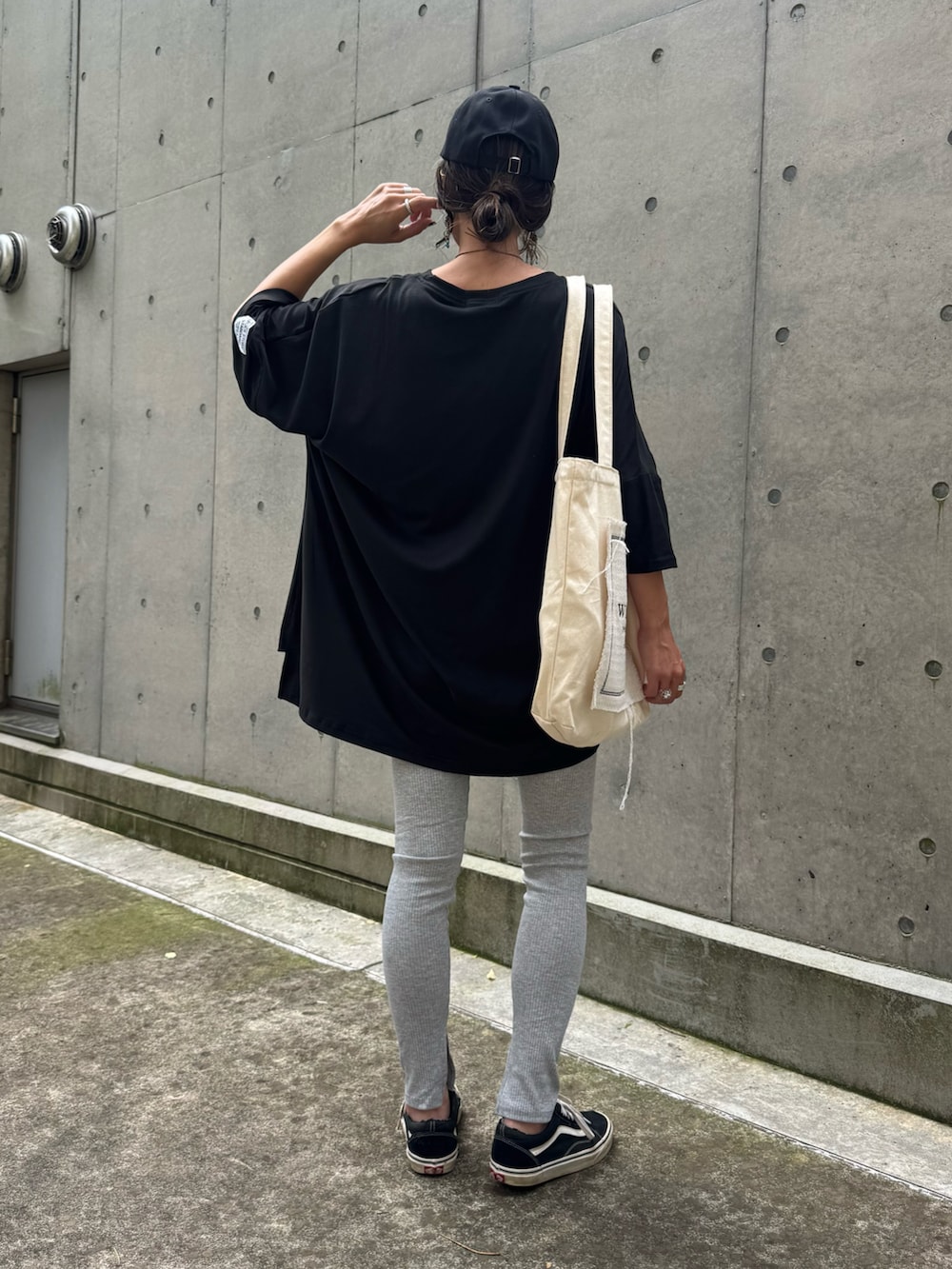 ブラック系のTシャツ/カットソー、ホワイト系のトートバッグ、ブラック系のスニーカーを着用したレディースの夏コーディネートの3枚目の写真