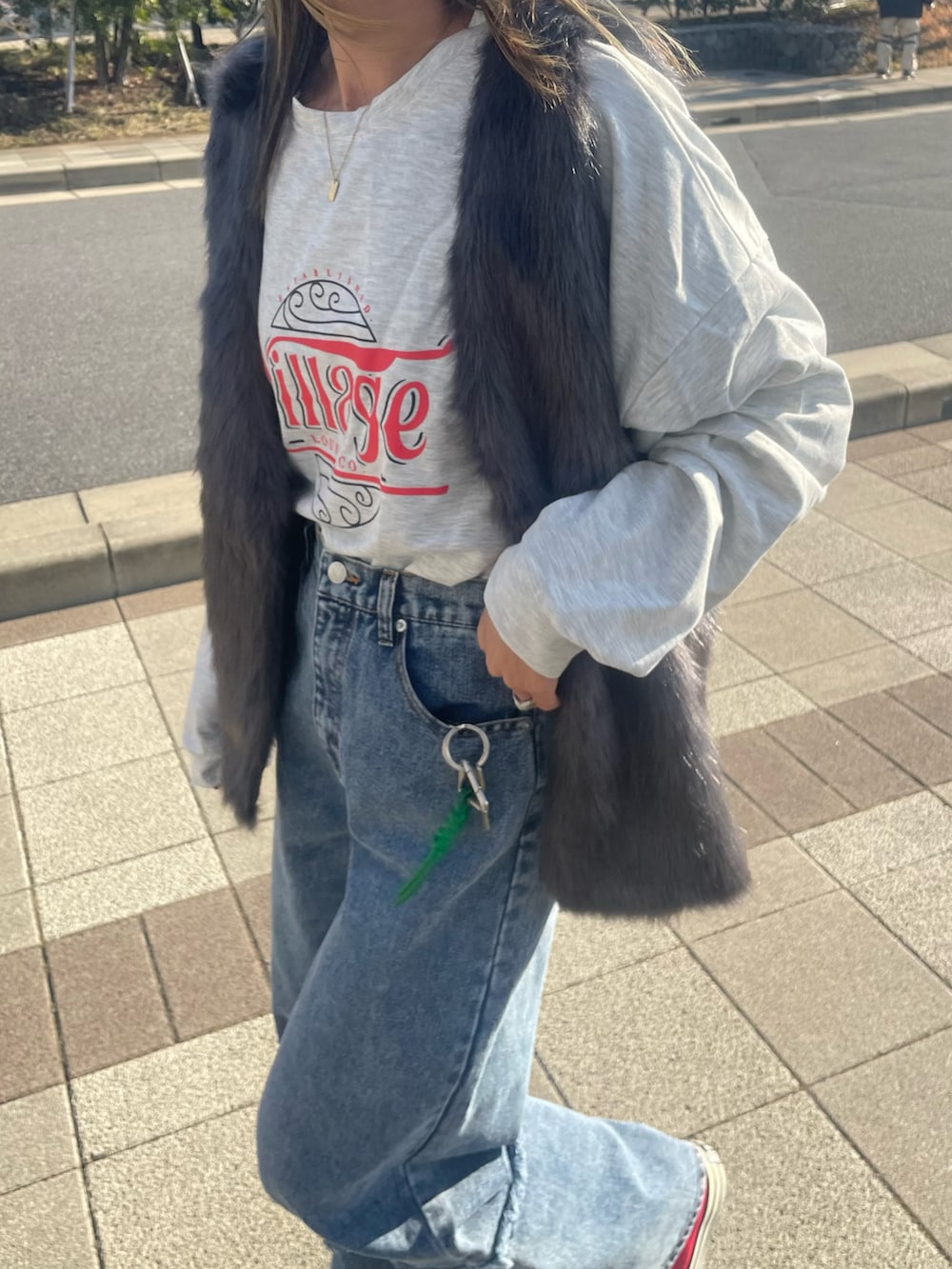 ホワイト系のTシャツ/カットソー、グレー系のベスト、ブルー系のデニムパンツを着用したレディースの冬コーディネートの2枚目の写真
