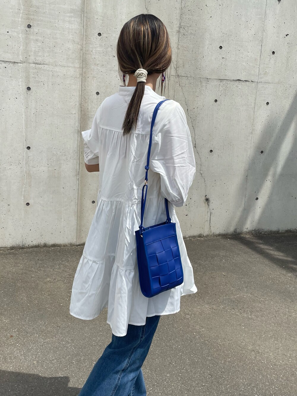 ホワイト系のシャツ/ブラウス、ブルー系のデニムパンツ、ブルー系のショルダーバッグを着用したレディースの春コーディネートの4枚目の写真