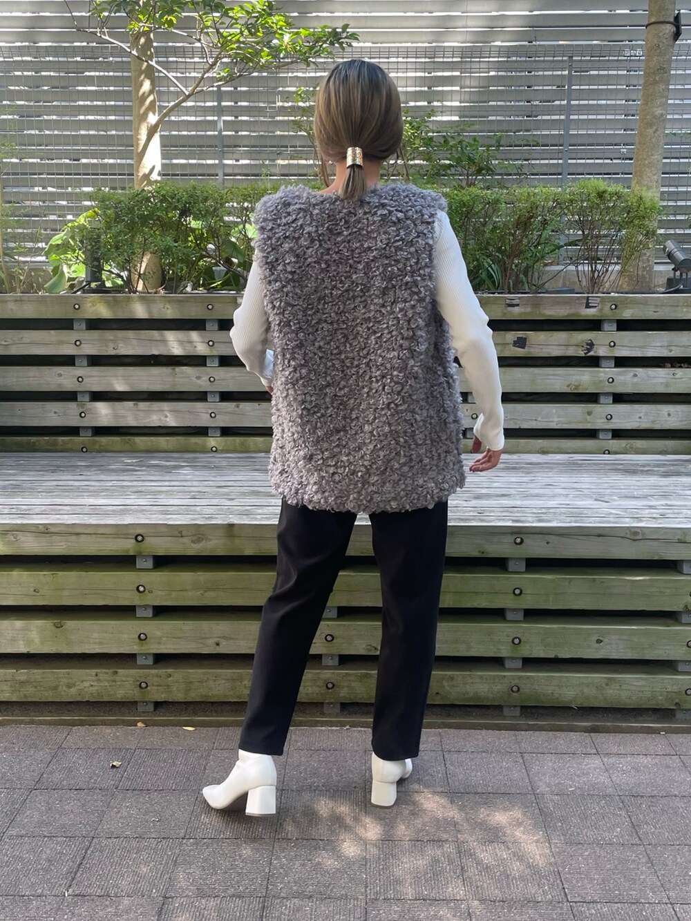 グレー系のベスト、ホワイト系のTシャツ/カットソー、ブラック系のその他パンツを着用したレディースの秋コーディネートの2枚目の写真