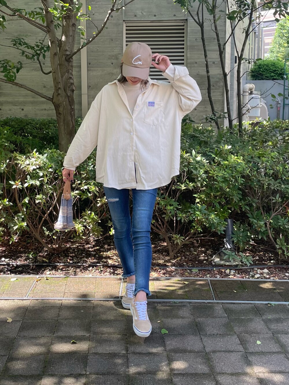 ホワイト系のシャツ/ブラウス、ホワイト系のニット/セーター、ブルー系のデニムパンツを着用したレディースの秋コーディネートの2枚目の写真