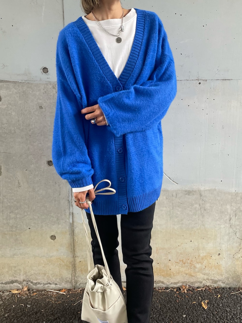 ブルー系のカーディガン/ボレロ、ブラック系のデニムパンツ、ホワイト系のスニーカーを着用したレディースの冬コーディネートの4枚目の写真
