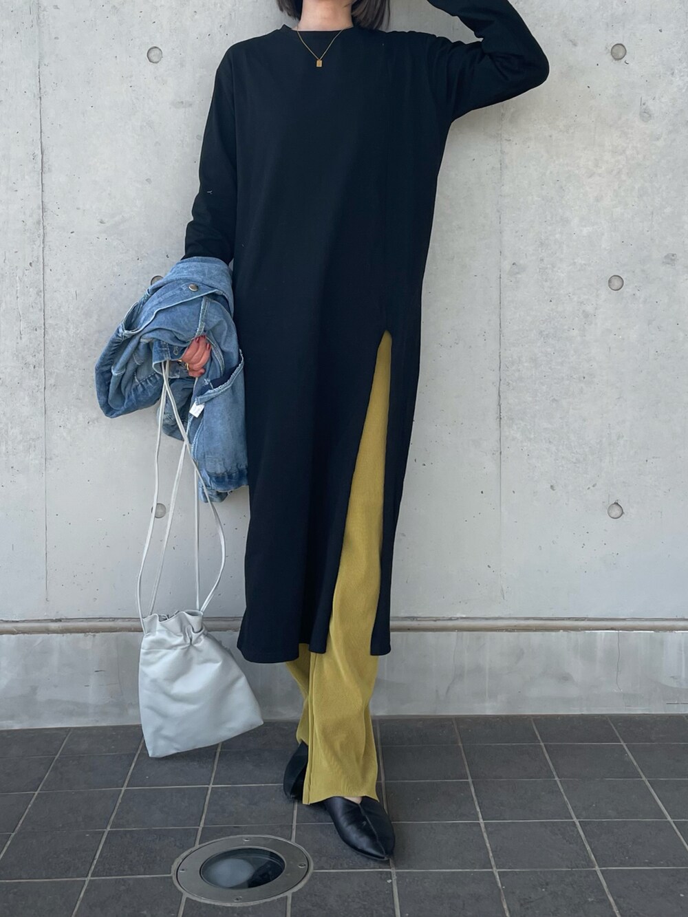ブラック系のワンピース、グレー系のショルダーバッグ、ブルー系のデニムジャケットを着用したレディースの春コーディネートの2枚目の写真