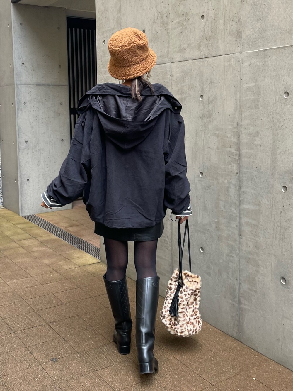 ブラック系のマウンテンパーカー、グレー系のTシャツ/カットソー、ブラック系のスカートを着用したレディースの秋コーディネートの2枚目の写真