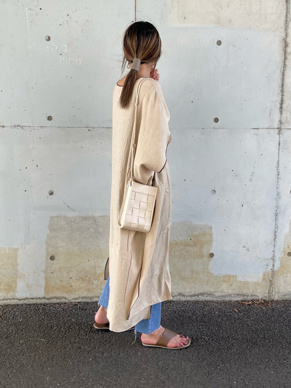 ベージュ系のワンピース、ブルー系のデニムパンツ、ブラウン系のサンダルを着用したレディースの夏コーディネートの3枚目の写真