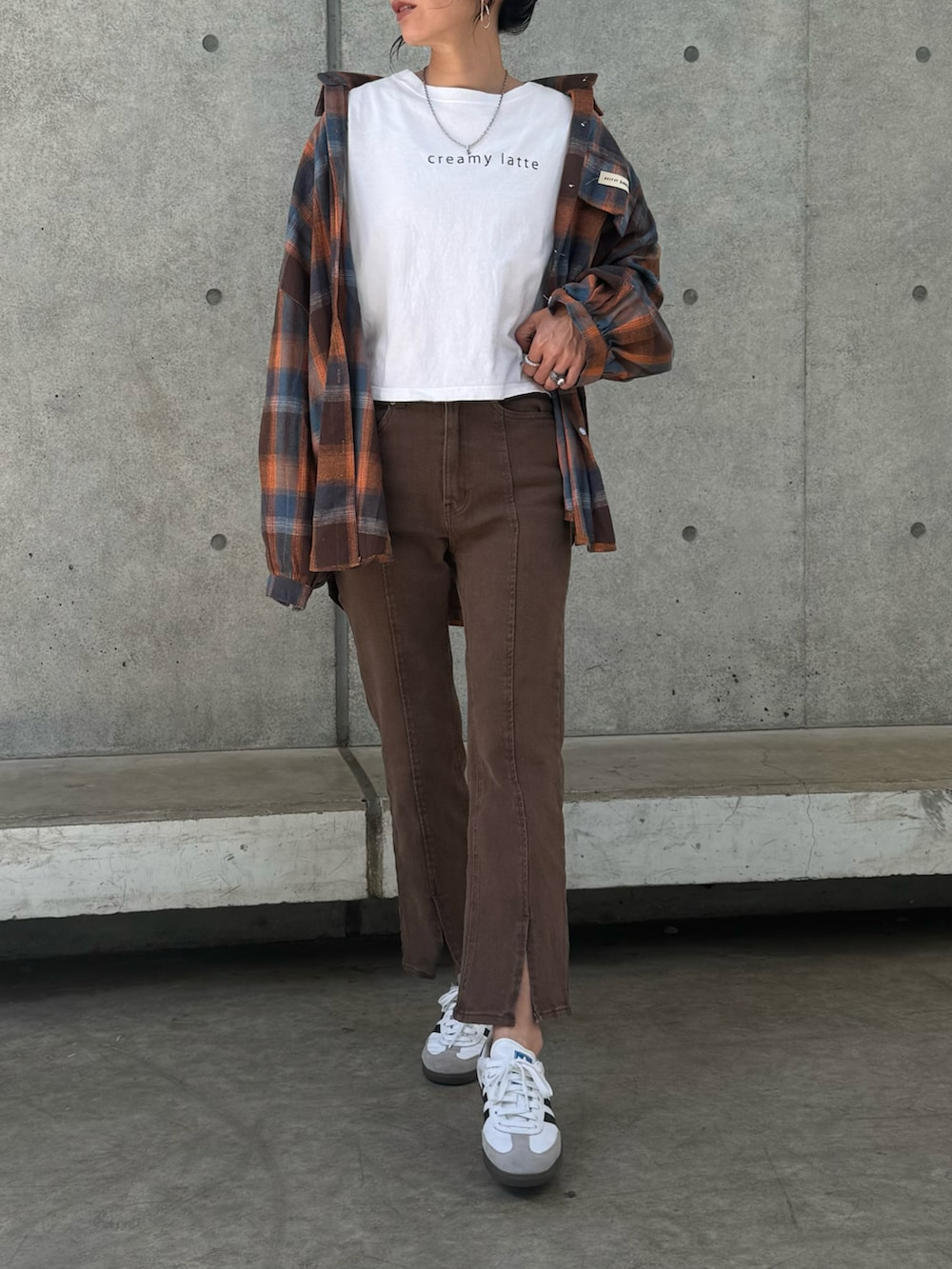 ブラウン系のシャツ/ブラウス、ブラウン系のデニムパンツ、ホワイト系のスニーカーを着用したレディースの春コーディネートの3枚目の写真